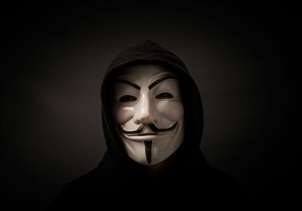 Bełchatow, Poland - December 06, 2015: Man wearing Vendetta mask - symbol for the online hacktivist group Anonymous. Black background.